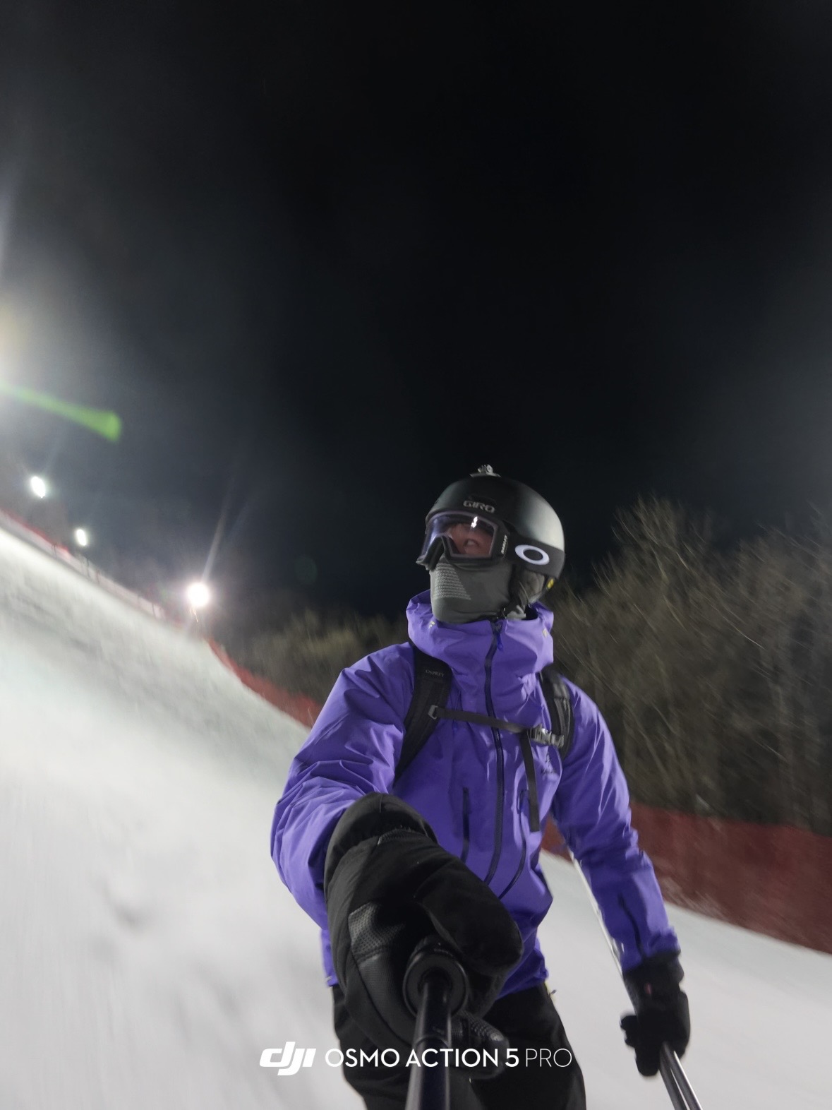 Zhuohan skiing at night in a purple jacket on a floodlit slope